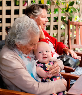 An elderly lady with dementia holding a baby