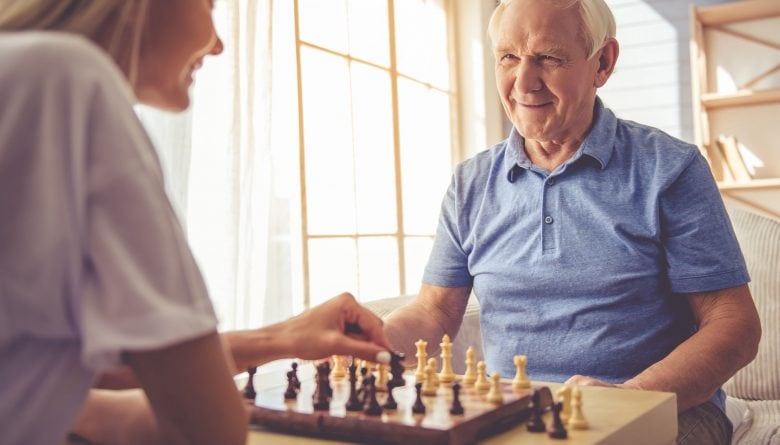 Granddaughter playing a game of chess with her grandfather