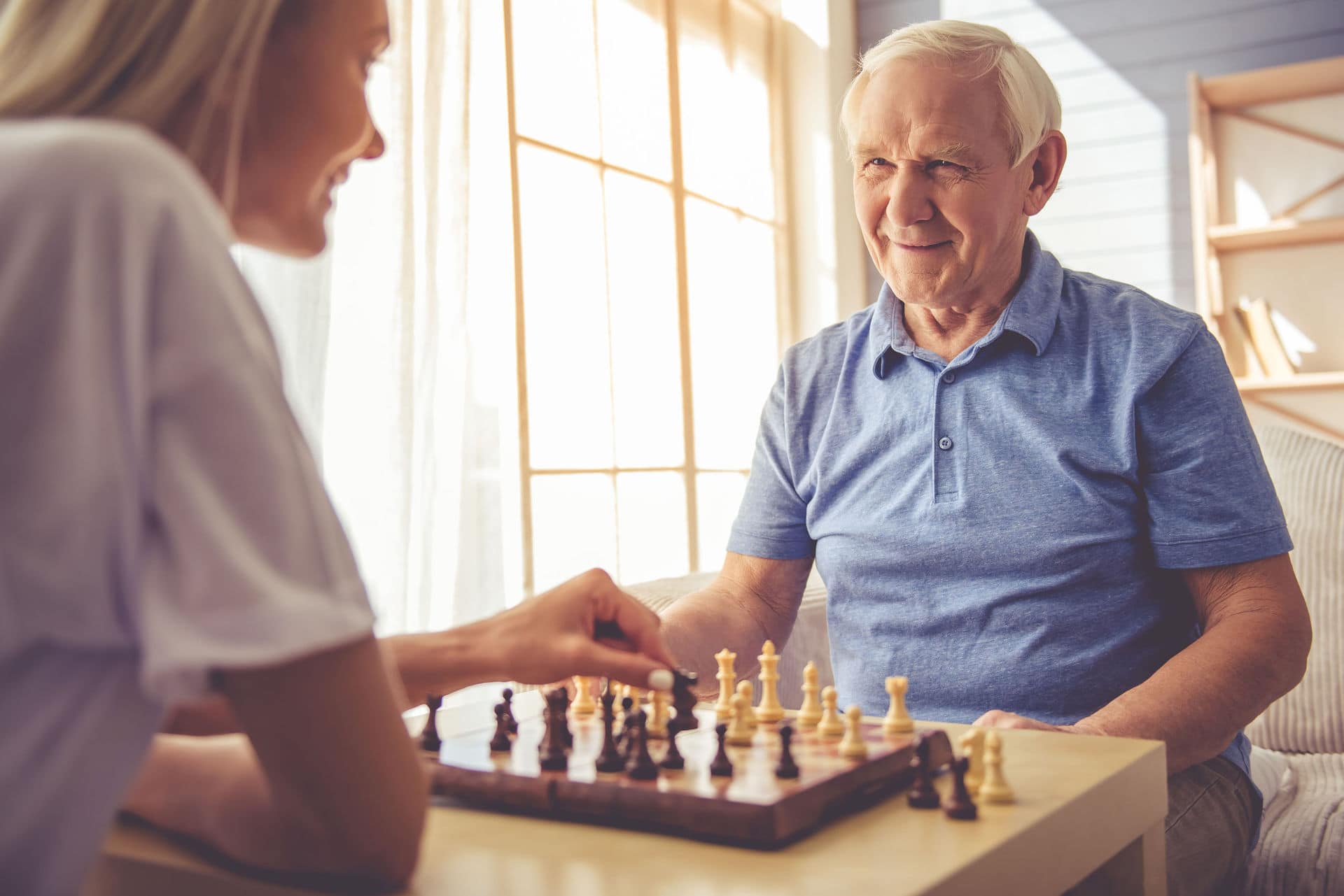 Granddaughter playing a game of chess with her grandfather