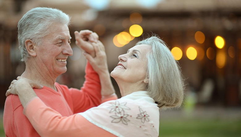 Senior couple dancing in their backyard